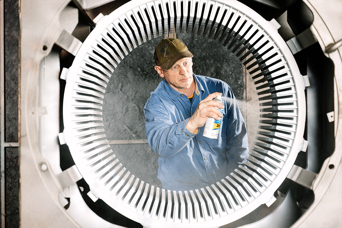 H&N Electric technician spraying inside a electric turbine while providing reliable performance and predictive maintenance