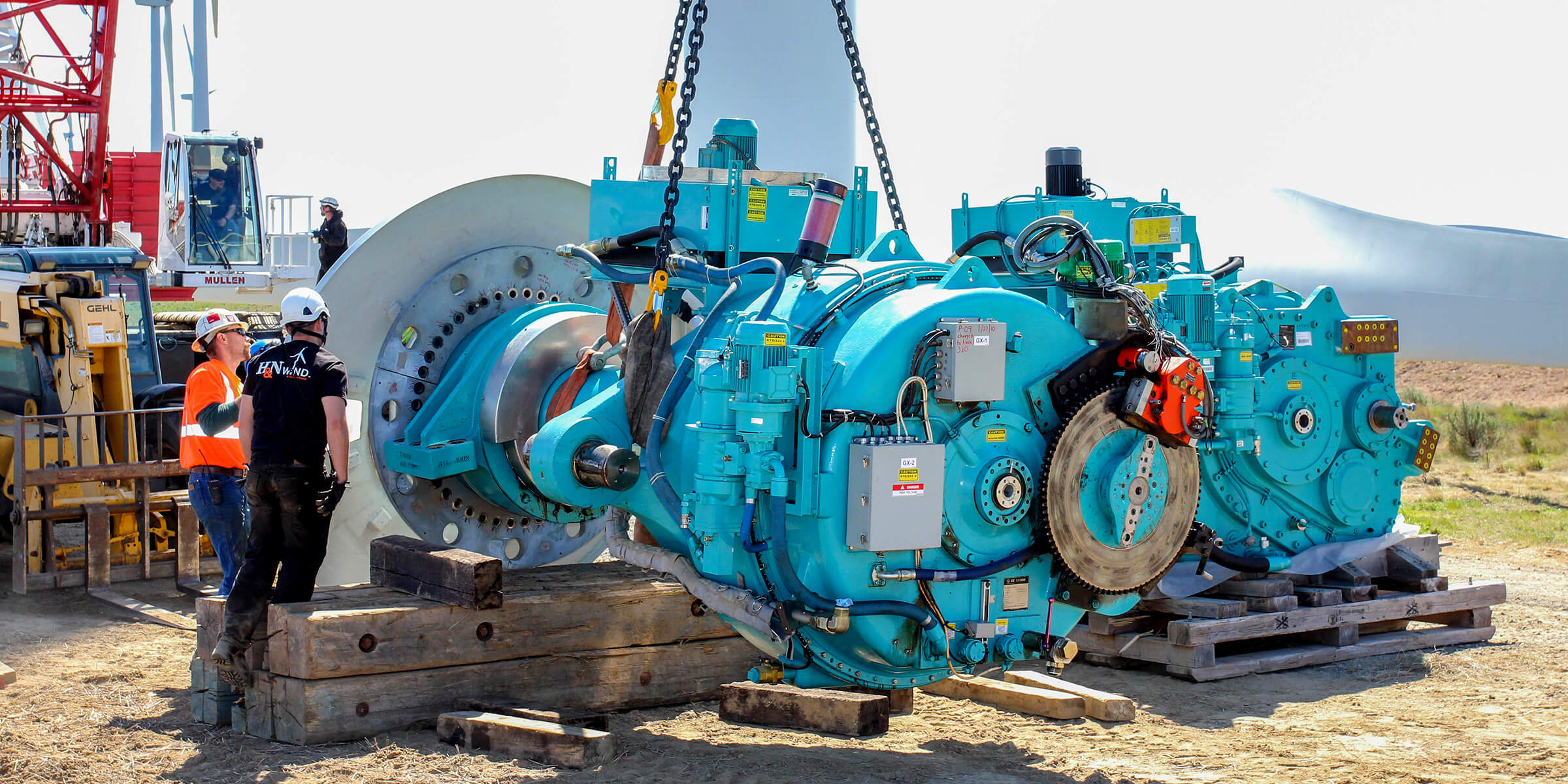 H&N Electric technicians hoisting a large industrial drivetrain with a crane on-site