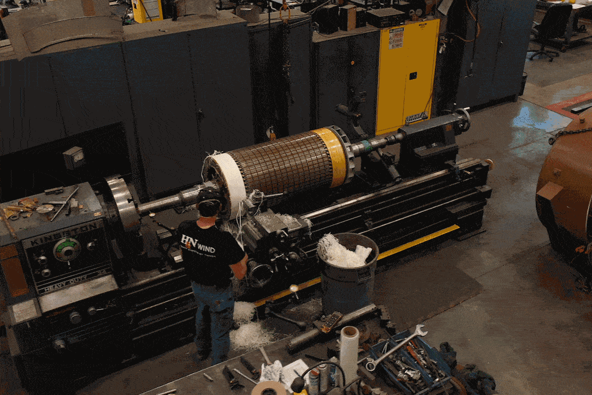 Moving image of an H&N Electric technician pulling material off of an industrial turning lathe machine