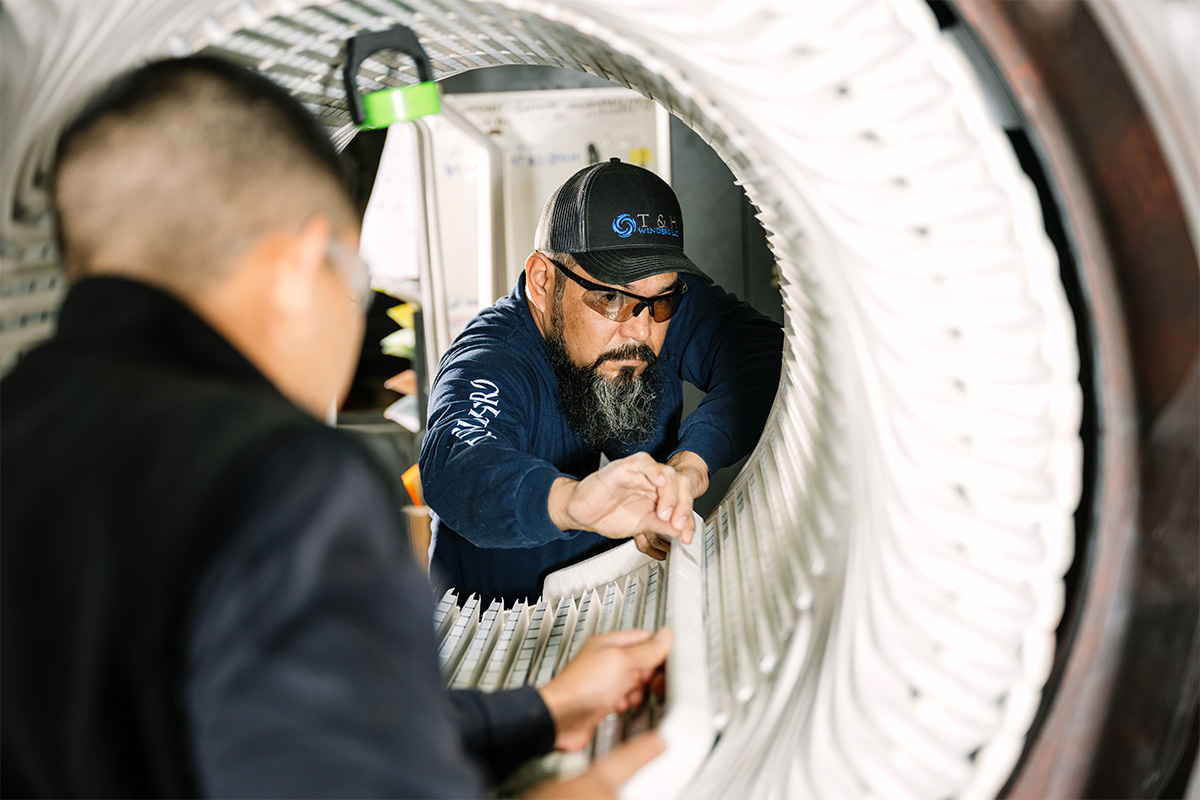 Two H&N Electric technicians work on the coil winding of an electrical generator as part of electric motor and generator performance and predictive maintenance