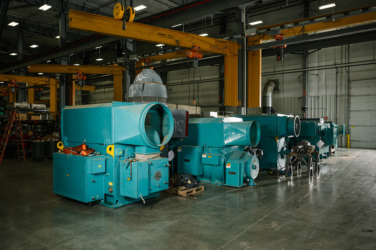 Several large electric motor and drivetrain components are stored inside the H&N Electric fully-equipped facility
